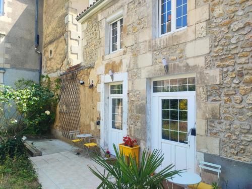 a stone building with a white door and a patio at La Green Room in Poitiers