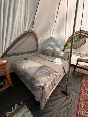 a bed in a tent in a room at Bluestone Acres Farm in Vavenby