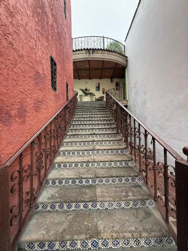 a stairway leading to a building with red walls at Hotel Hacienda Tonalmain, Central Nueva in Guadalajara