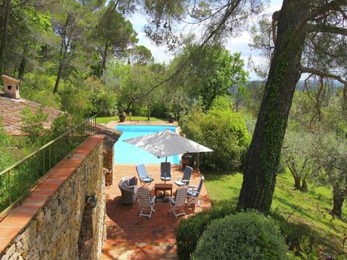 a table and chairs with an umbrella next to a pool at Mansion in Var with Private Pool in Tourrettes