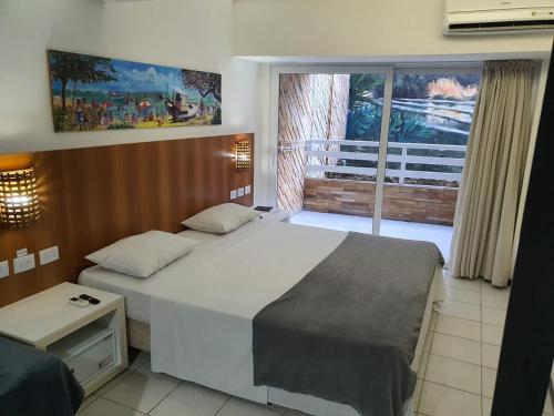 a bedroom with a large bed and a balcony at Apartamento Praia do Centro Pipa in Pipa