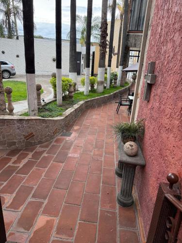 a brick walkway with a bench with plants on it at Hotel Hacienda Tonalmain, Central Nueva in Guadalajara