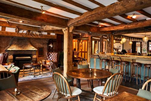 a restaurant with tables and chairs and a fireplace at Hotel Indigo - Stratford Upon Avon by IHG in Stratford-upon-Avon