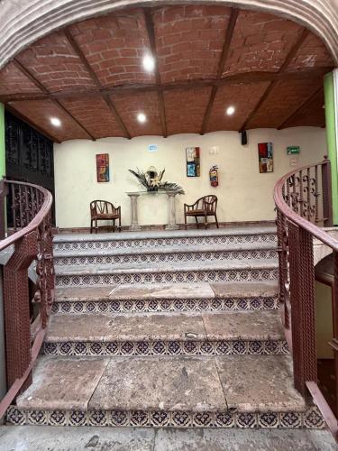 a set of stairs with a table and chairs at Hotel Hacienda Tonalmain, Central Nueva in Guadalajara
