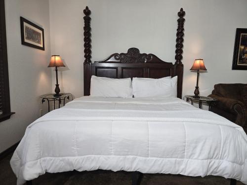 a bedroom with a large white bed with two lamps at Fredericksburg Escape Wineries & Hot Tub in Fredericksburg