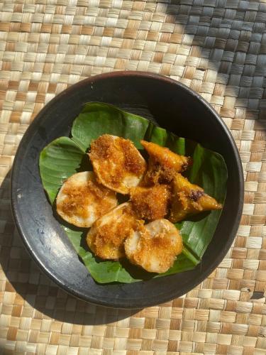 una ciotola piena di cibo sopra la lattuga di Alang Cottage a Masbagik