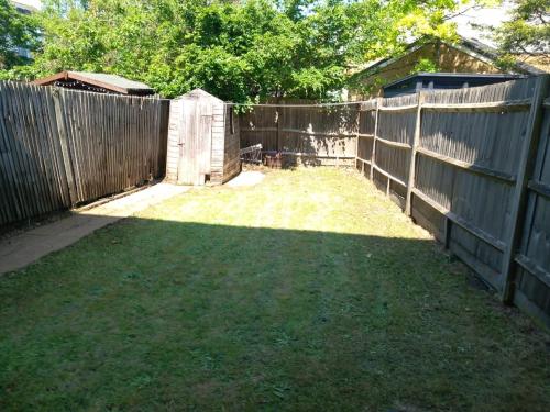 a backyard with a fence and a grass yard at Cosy 1-Bed Studio in Northolt perfect to unwind in Northolt
