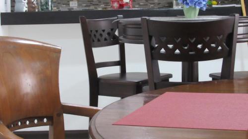 a table with black chairs and a table with a pink rug at Hotel Boutique CasAguacate close to Airport, Pedregal, Centro de Convenciones de Costa Rica in Potrerillos