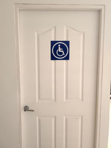 a white door with a sign on it at Hotel Boutique CasAguacate close to Airport, Pedregal, Centro de Convenciones de Costa Rica in Potrerillos