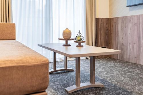 a room with a table with a vase on it at Apartment Hotel 11 Higashi Umeda in Osaka