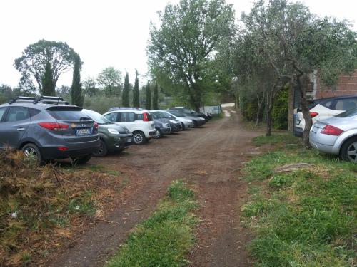 a row of cars parked on the side of a dirt road at Piccolo Feudo Green Resort in Viterbo