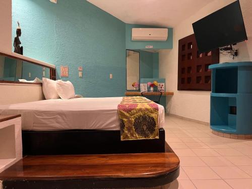 a bedroom with a bed and a flat screen tv at Cerezas in Cancún