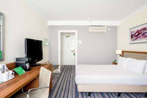 a hotel room with a bed and a tv at Holiday Inn Leeds-Wakefield M1 Jct40 by IHG in Wakefield