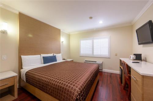 a hotel room with a bed and a television at Hollywood City Inn in Los Angeles