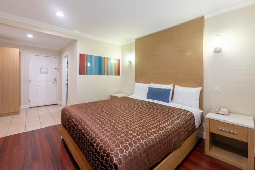 a hotel room with a bed and a hallway at Hollywood City Inn in Los Angeles