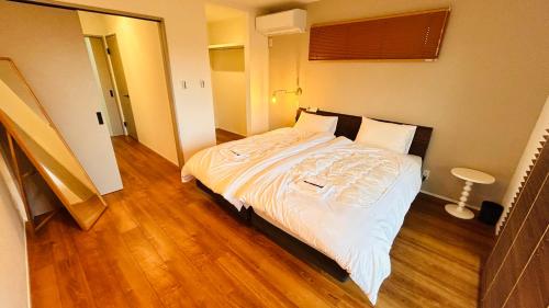 a bedroom with a bed with white sheets and pillows at HiL town yamanashi 07 STAY BACK in Kofu