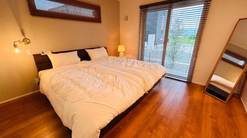 a large bed in a bedroom with a large window at HiL town yamanashi 07 STAY BACK in Kofu