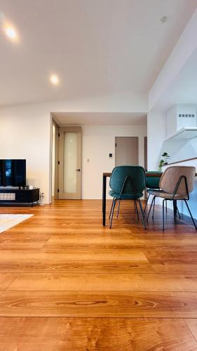 a living room with a table and chairs on a wooden floor at HiL town yamanashi 07 STAY BACK in Kofu