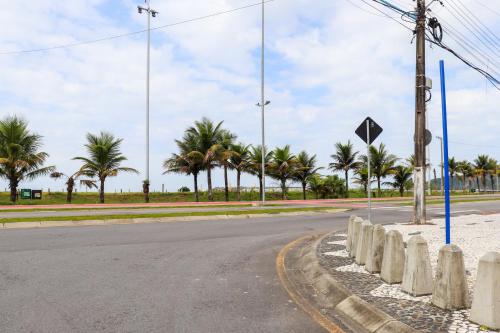an empty street with palm trees in the background at Apartamento Garden Caiobá com Piscina Praia Brava in Matinhos