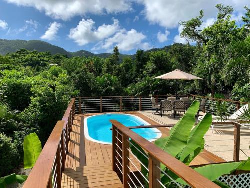 a deck with a pool and a table and chairs at New Moon Escape - Affordable, Private Cottage with a Pool, WIFI and AC in Coral Bay