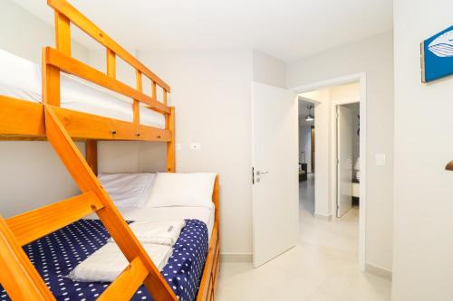a bunk bed in a room with a ladder at Apartamento Garden Caiobá com Piscina Praia Brava in Matinhos