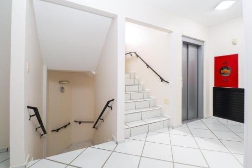 a hallway with stairs and a red wall at Apartamento Garden Caiobá com Piscina Praia Brava in Matinhos