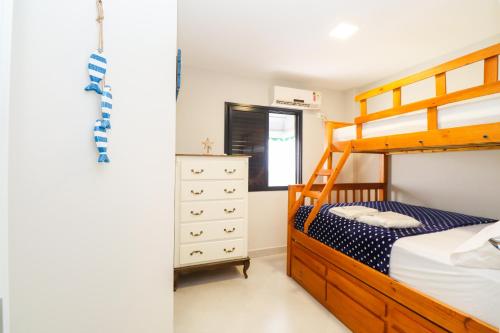 a bedroom with a bunk bed and a dresser at Apartamento Garden Caiobá com Piscina Praia Brava in Matinhos