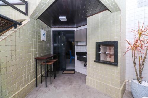a room with green tile walls and a table and a counter at Apartamento Garden Caiobá com Piscina Praia Brava in Matinhos