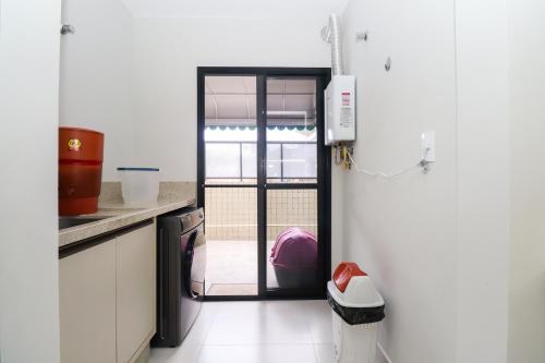a kitchen with a door leading into a kitchen with at Apartamento Garden Caiobá com Piscina Praia Brava in Matinhos