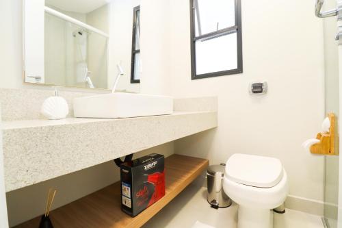 a bathroom with a sink and a toilet at Apartamento Garden Caiobá com Piscina Praia Brava in Matinhos