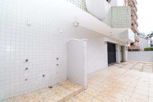 a room with white tiled walls and a courtyard at Apartamento Garden Caiobá com Piscina Praia Brava in Matinhos