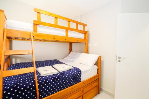 a bedroom with a bunk bed with two towels at Apartamento Garden Caiobá com Piscina Praia Brava in Matinhos