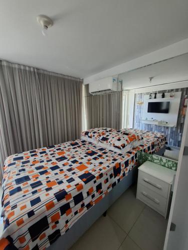 a bedroom with a bed with a colorful comforter at Flat vista mar de Intermares completíssimo 508 in João Pessoa