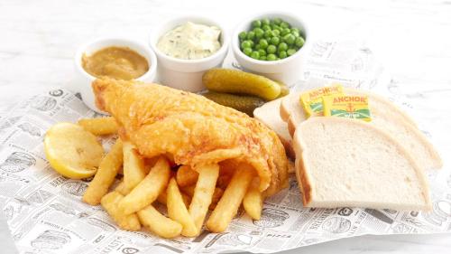 a plate of food with a fish sandwich and french fries at Holiday Inn Stoke on Trent M6 Jct15 by IHG in Stoke on Trent