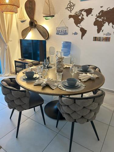 a dining room table with chairs and a table with plates and wine glasses at Atmospheric apartment with a beautiful view of the swimming pool in Bayahibe