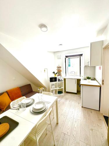 a living room with a table and a kitchen at BrightHouse Nazaré - Modern Apartments in Nazaré