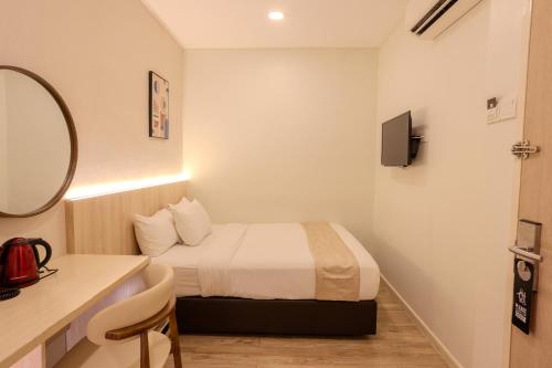 a small room with a bed and a mirror at Innspire Hotel by Suntai in Port Dickson
