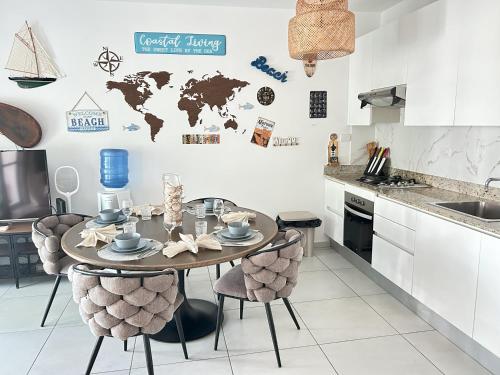 a kitchen with a table and chairs with a world map on the wall at Atmospheric apartment with a beautiful view of the swimming pool in Bayahibe