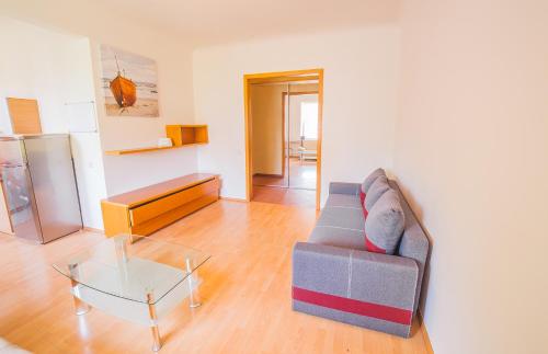 Heart of Old-Town Apartments في ريغا: غرفة معيشة مع أريكة وطاولة زجاجية