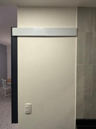 a white door in a room with a table at Flat Assinado e Sofisticado in Vitória