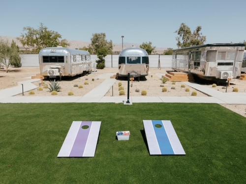 a group of rvs parked in a parking lot at Acres Landing in Desert Hot Springs