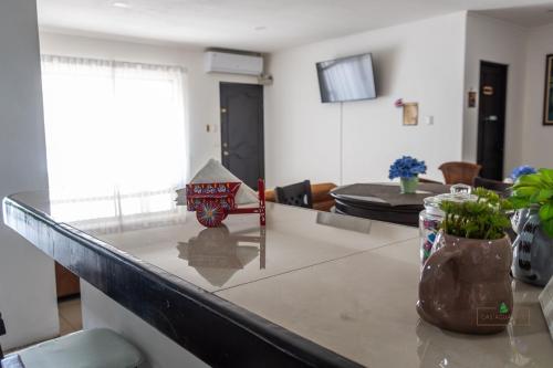 a kitchen with a counter top and a dining room at Hotel Boutique CasAguacate close to Airport, Pedregal, Centro de Convenciones de Costa Rica in Potrerillos