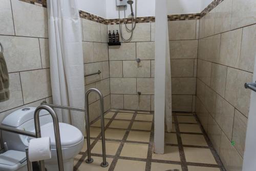 a bathroom with a shower and a toilet at Hotel Boutique CasAguacate close to Airport, Pedregal, Centro de Convenciones de Costa Rica in Potrerillos