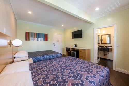 a hotel room with a bed and a bathroom at Hollywood City Inn in Los Angeles