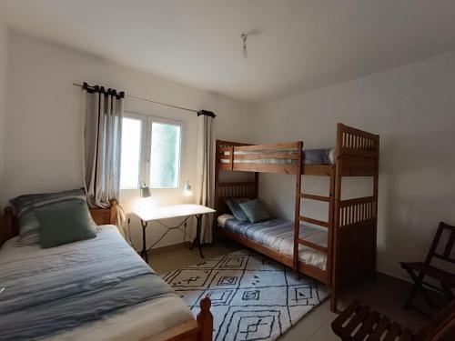 une chambre avec deux lits superposés et une fenêtre dans l'établissement Villa familiale en bord de mer avec 6 chambres, WiFi, animaux admis, proche Saint-Brevin-l'Océan - FR-1-364-170, à Saint-Brévin-les-Pins