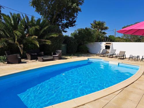 une piscine avec de l'eau bleue dans une cour dans l'établissement Maison confortable avec piscine privée, 3 chambres, proche forêt et plage. - FR-1-323-542, à Saint-Jean-de-Monts