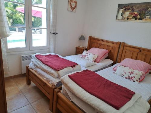 deux lits jumeaux dans une chambre avec fenêtre dans l'établissement Maison confortable avec piscine privée, 3 chambres, proche forêt et plage. - FR-1-323-542, à Saint-Jean-de-Monts