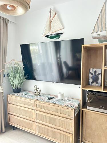 a wooden dresser in a room with a large mirror at Caribbean Dream Condo AC WIFI in La Laguna