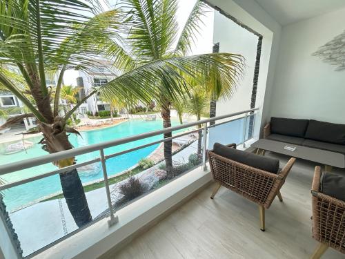 a balcony with a view of a pool and palm trees at Caribbean Dream Condo AC WIFI in La Laguna