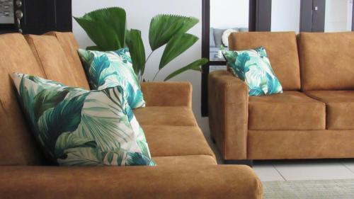 a living room with a couch and a chair at Hotel Boutique CasAguacate close to Airport, Pedregal, Centro de Convenciones de Costa Rica in Potrerillos